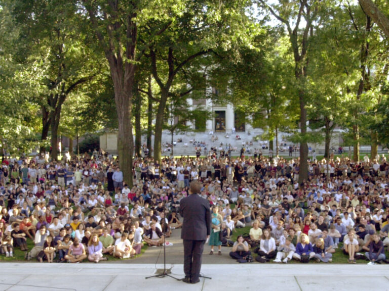 The Harvard president standing in front of a crowd