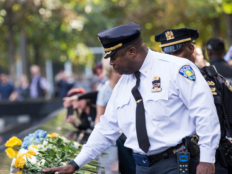 A police officer putting flowers on a grave