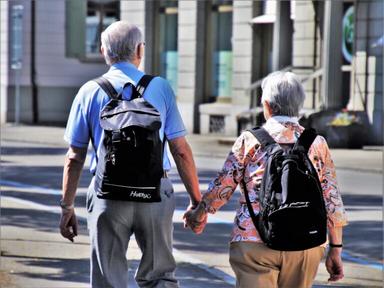 Two older people walking with backpacks on